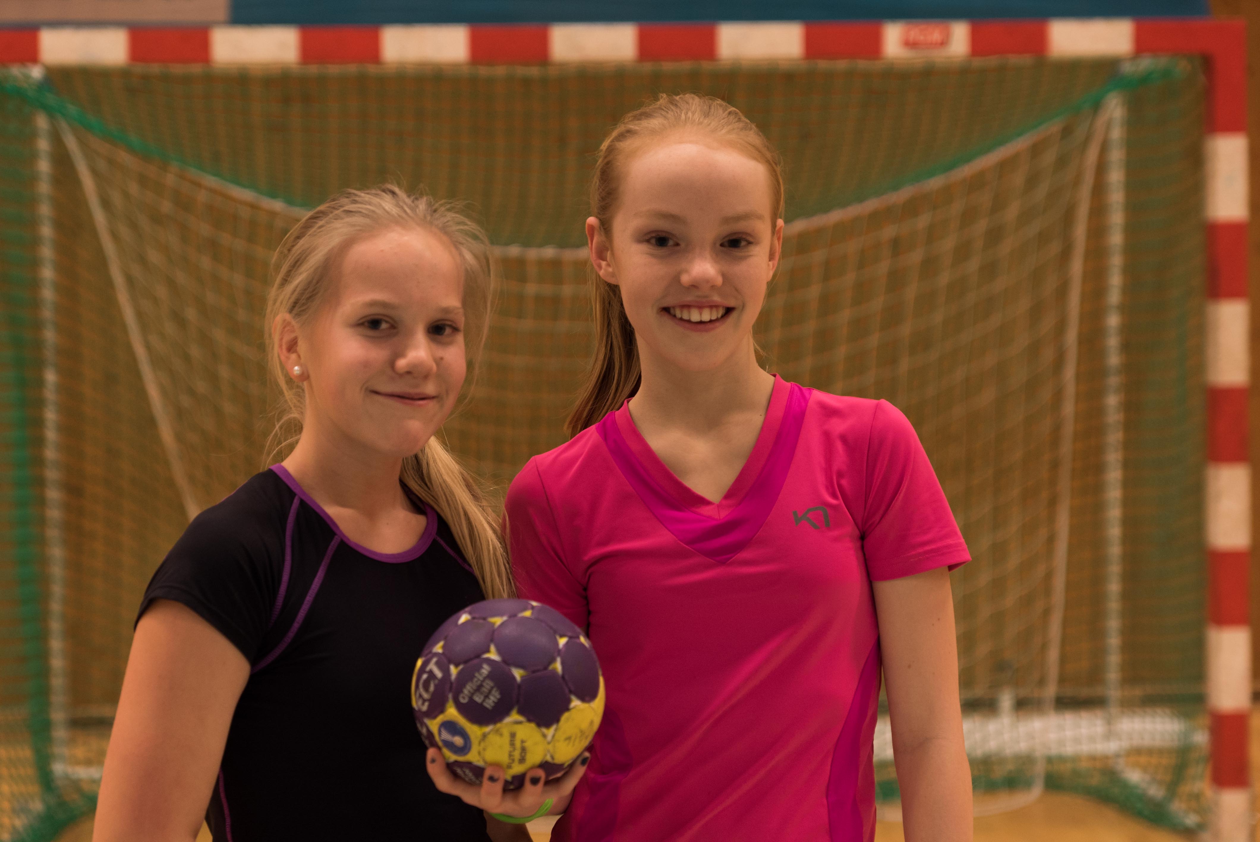 To jenter med håndball foran et håndballmål