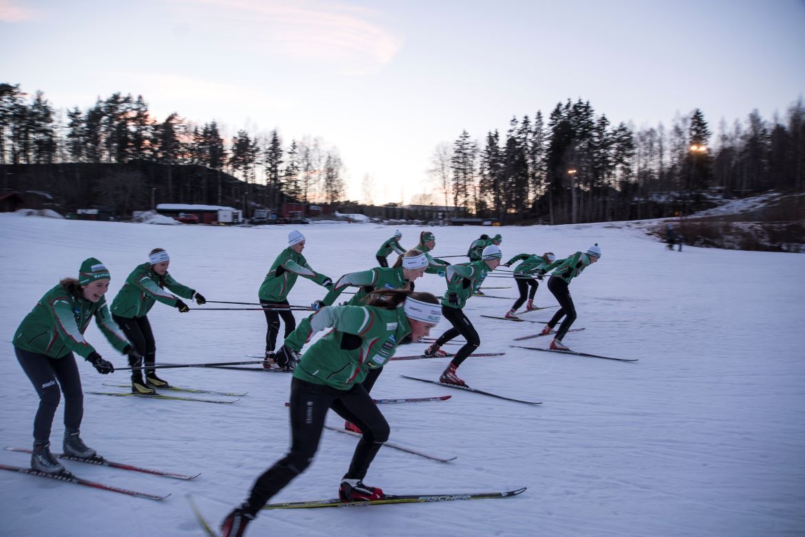 Ungdom på ski som trekker andre ungdom på ski